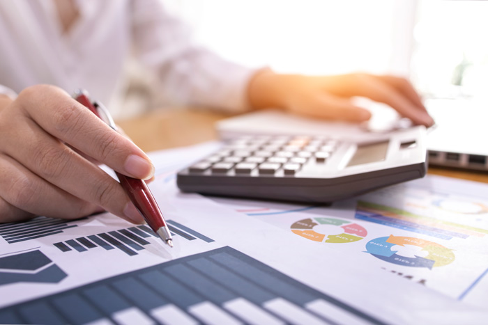 Papper på ett bord med en miniräknare